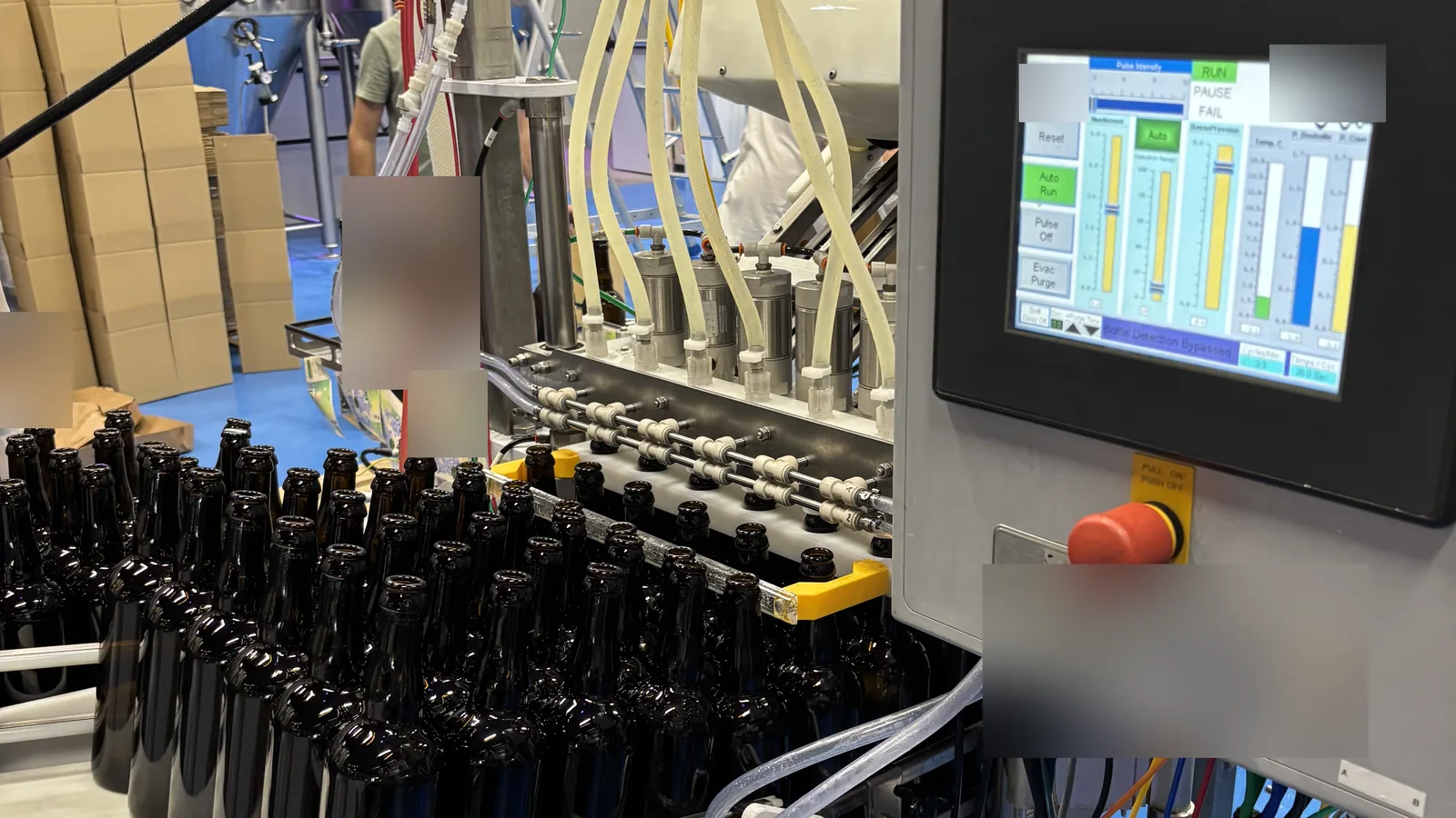 A six-head Meheen bottling machine with its control screen, installed on a brewery line